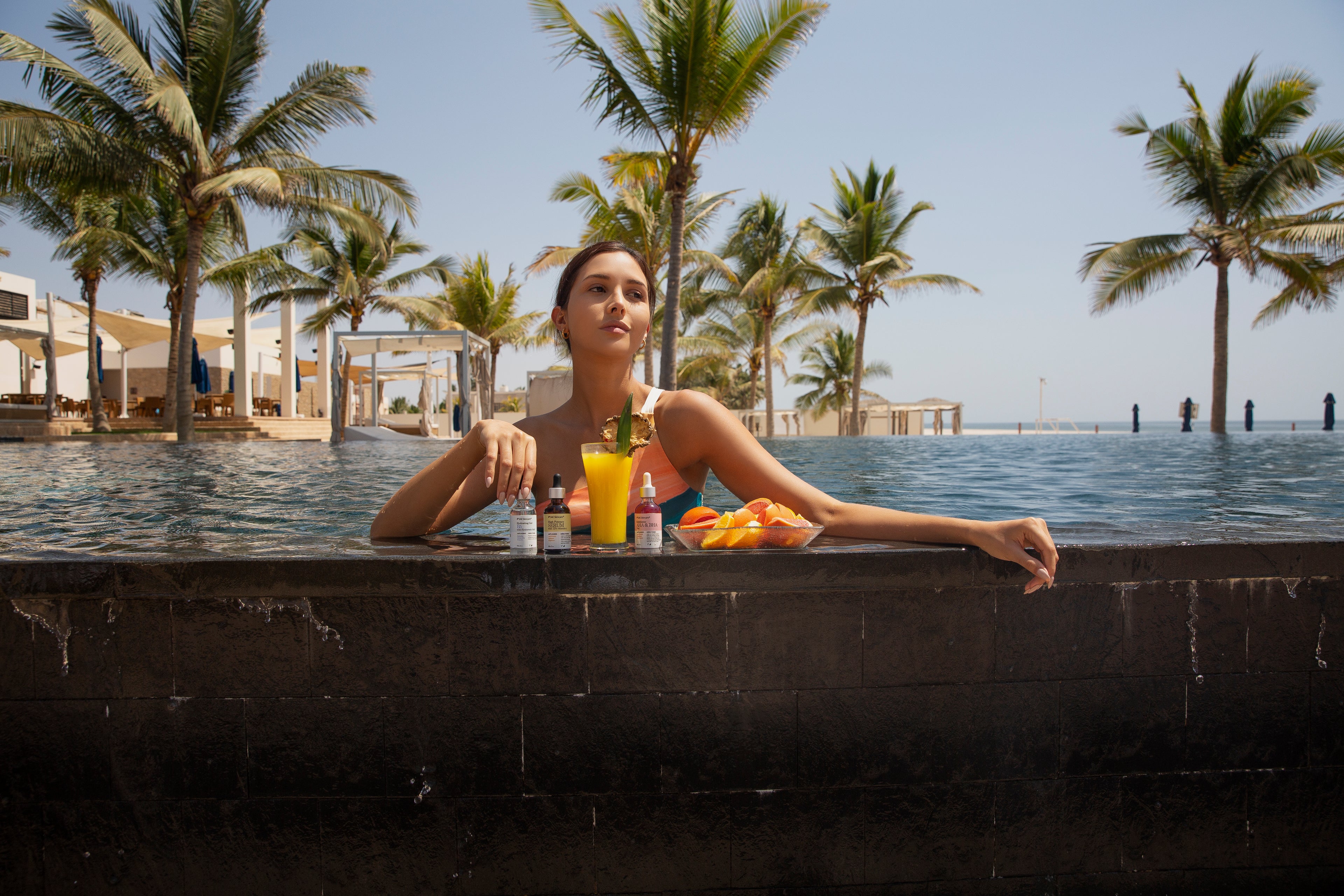 Woman relaxing by a pool with palm trees in the background